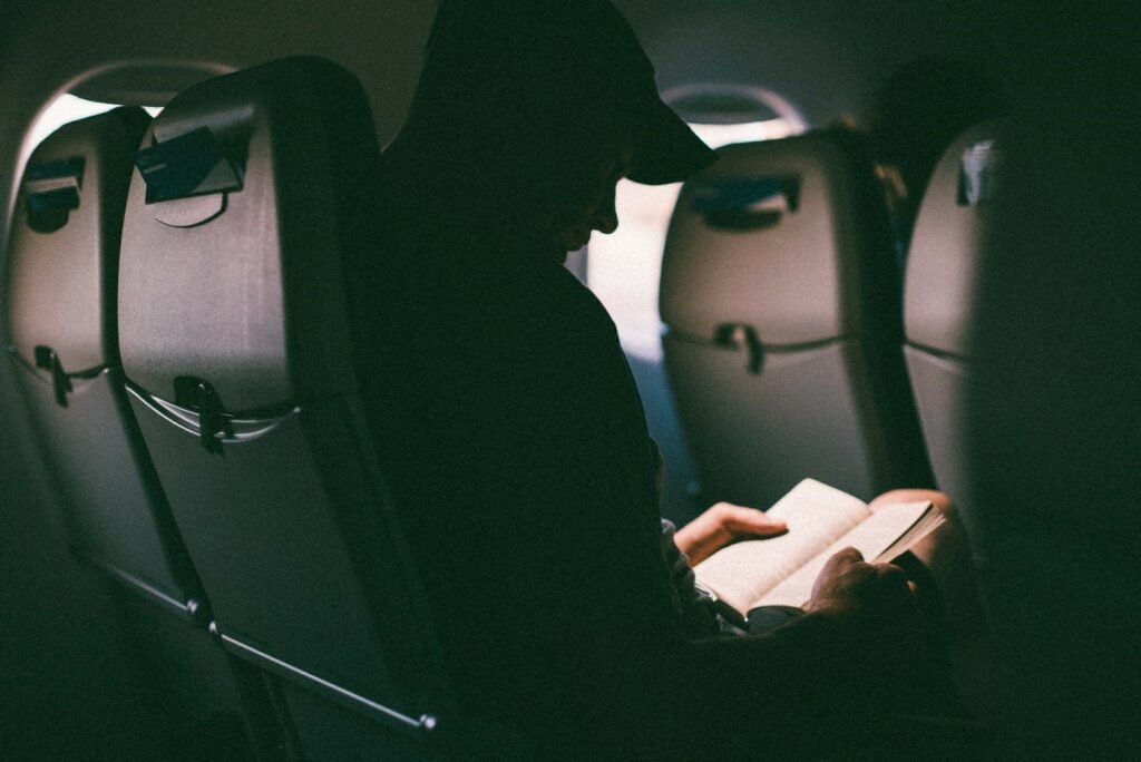 Man reading book in long flight 